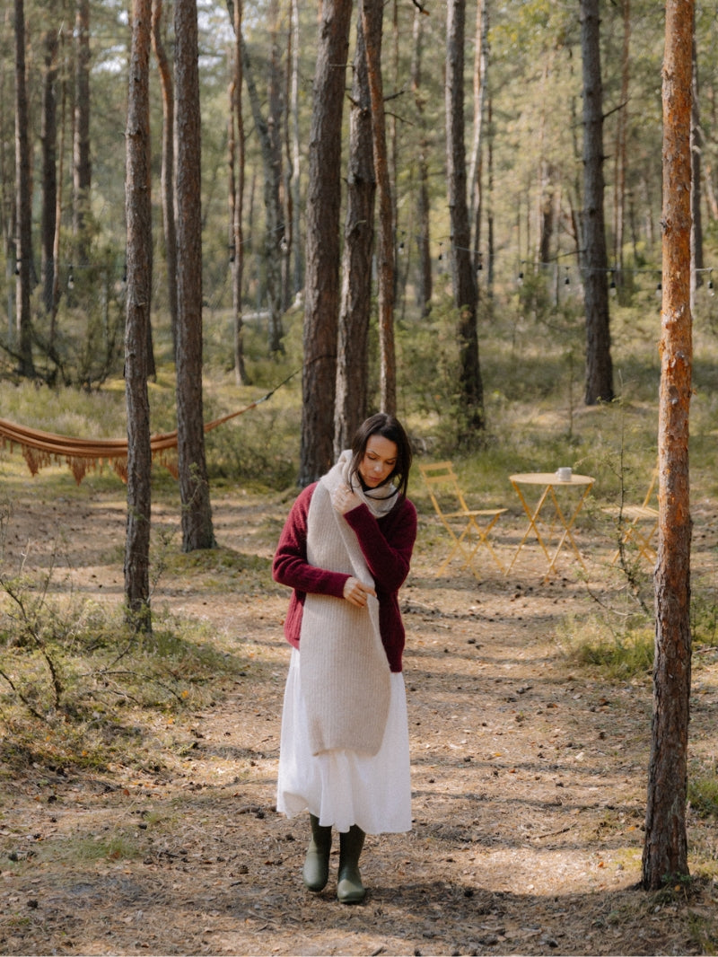 Długi beżowy szalik z wełny alpaki i jagnięcej w secie z bordowym kardiganem i długą lnianą białą sukienką