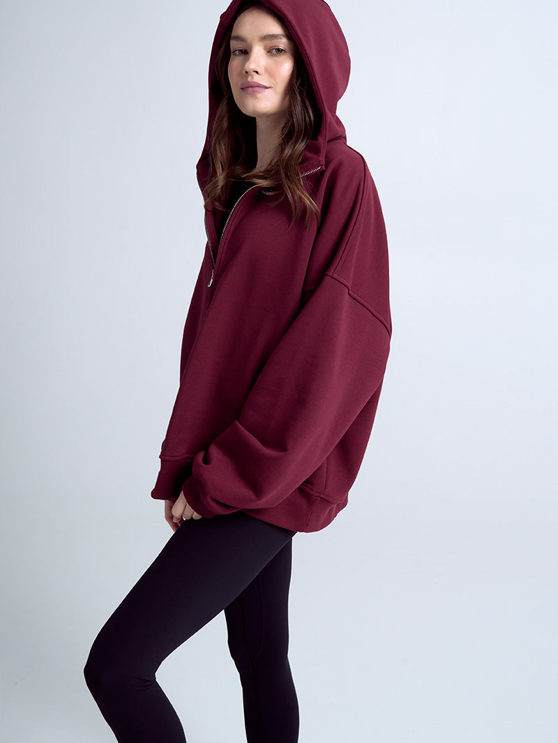 Bordowa, luźna bluza z kapturem damska na zamek Evolve - modelka w połączeniu z czarnymi legginsami