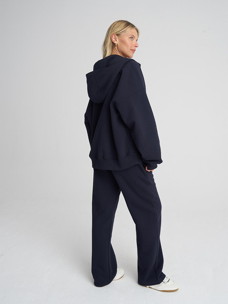 Granatowe, damskie luźne bawełniane spodnie dresowe EVOLVE - modelka z tyłu