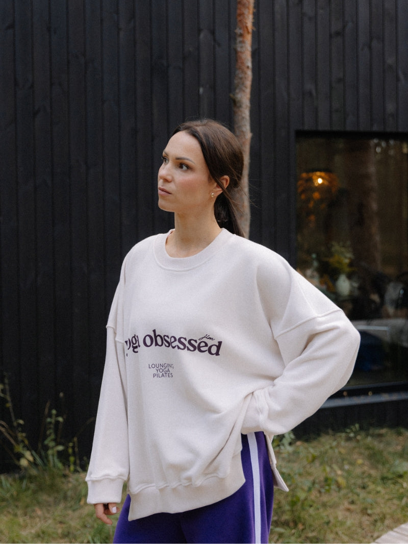 Luźna bawełniana bluza oversize KIND w kremowym kolorze z nadrukiem yoga obsessed - outfit z fioletowymi spodniami z lampasem