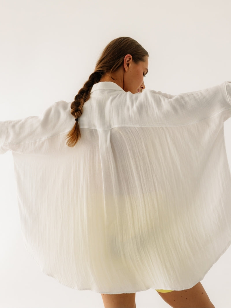 Dynamiczny ruch w kremowej koszuli Cloud Ecru z rękawem 3/4 - półprzezroczysta muślina w pięknym układzie podczas ćwiczeń