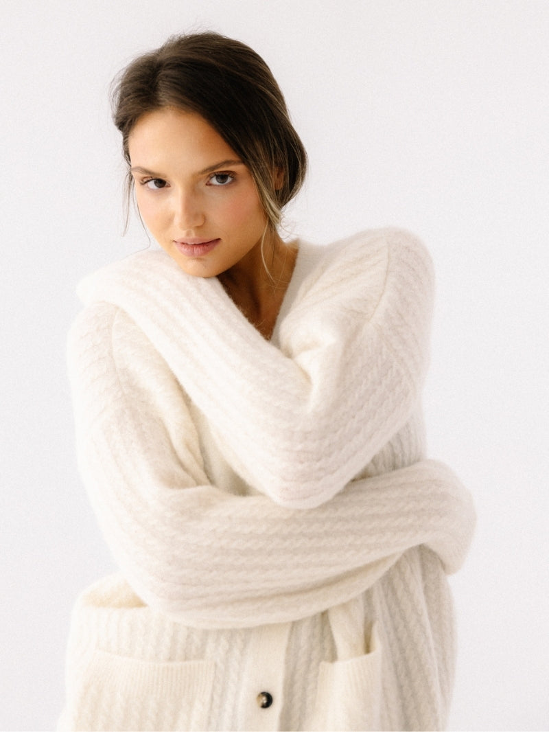 Miękki i ciepły sweter damski z alpaki i wełny jagnięcej w delikatnym kremowym odcieniu — delikatny dla skóry, o luźnym kroju oversize z kieszeniami