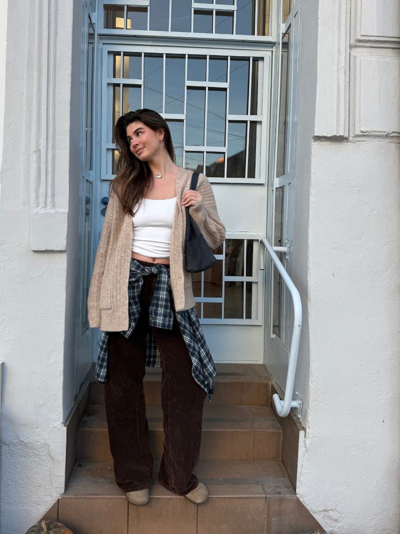 Jesienny outfit z kolekcji Cozy Escape - beżowy kardigan z wełny alpaki, flanelowa koszula w pasie, prosty biały top i szerokie spodnie w brązie