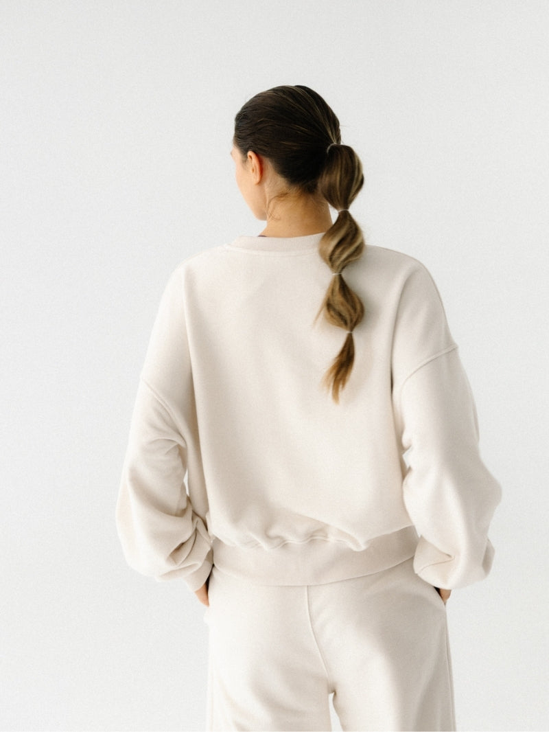 Szeroka damska bluza oversize w kremowym odcieniu z serii Spark — wysokiej jakości bawełna, minimalistyczny design, o skróconym fasonie