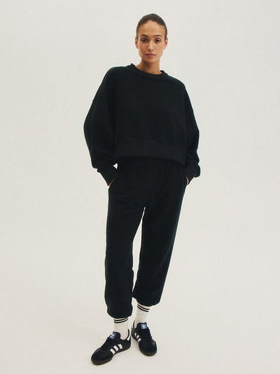 Pełna sylwetka w czarnej bluzie WAVE, prezentująca jej wszechstronność w praktyce jogi i na co dzień