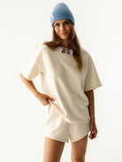 Modelka w kremowej bluzce Coast z niebieską czapką - casualowy look na co dzień