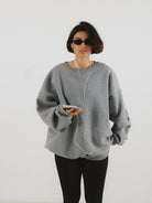 Szara damska bluza oversize z obniżoną linią ramion, wykonana z bawełny w projekcie Soft Rebel - widok na długość i ściągacz