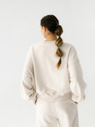 Szeroka damska bluza oversize w kremowym odcieniu z serii Spark — wysokiej jakości bawełna, minimalistyczny design, o skróconym fasonie